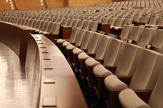 How do auditorium chairs, theater chairs, and ladder desks and chairs use ergonomics?