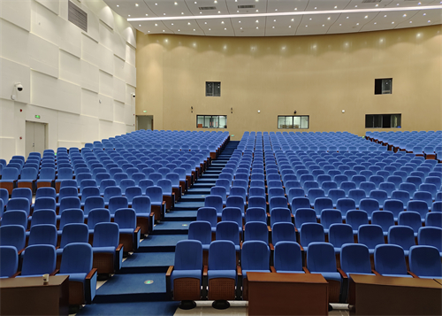 In addition to writing boards, what other practical configurations do auditorium chairs have?