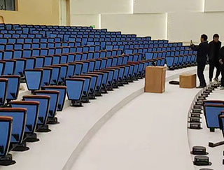 How to sit on auditorium chairs to make them most comfortable?